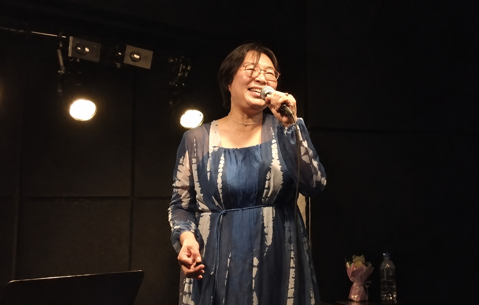 ステージ中央で笑顔で歌うPLUM